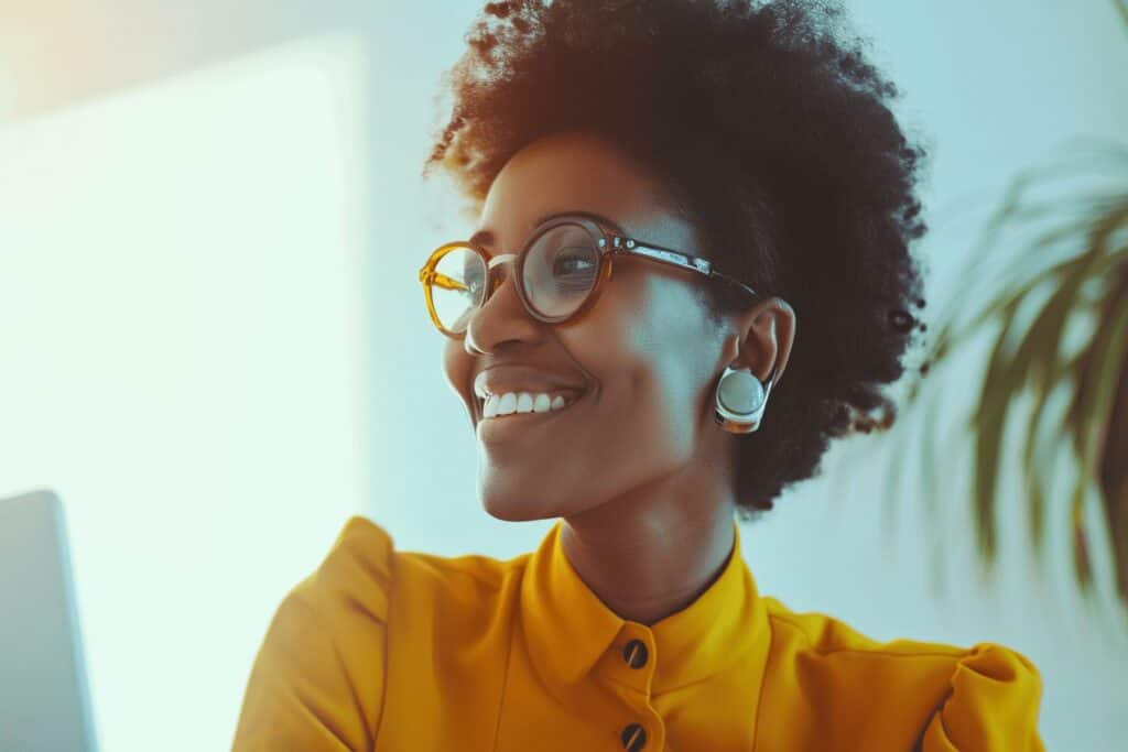 A woman wearing glasses is smiling in front of a plant implementing ai marketing automation.